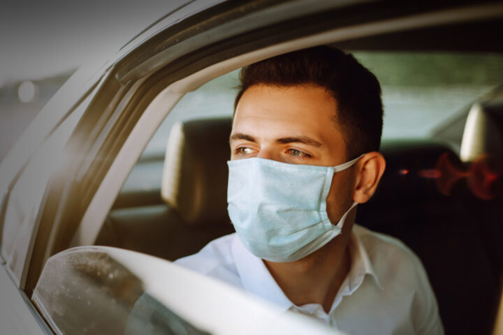 passenger wearing a mask inside a chauffeur vehicle