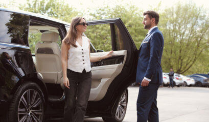 Chauffeur and passenger in front of Range Rover